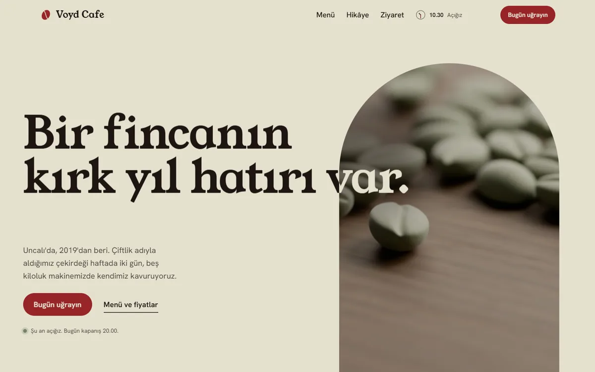 Voyd Cafe konsept sitesinin açılışı: solda “Bir fincanın kırk yıl hatırı var” başlığı, sağda kemerli bir pencerede ceviz masadaki yeşil kahve çekirdekleri; başlığın son kelimesi kemerin üstüne taşıyor.