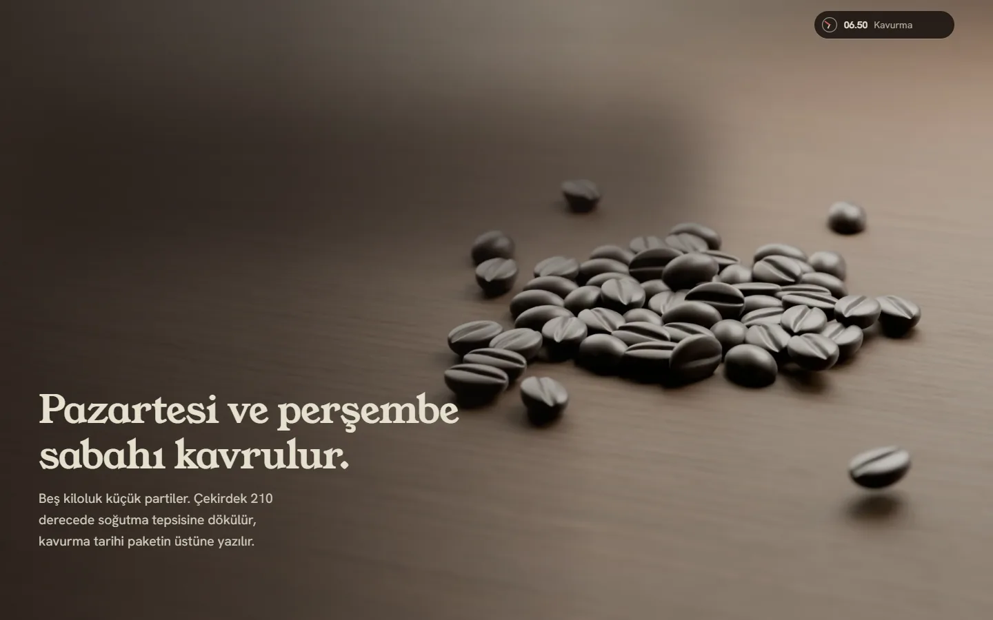 Voyd Cafe ana sayfasının filmi, masaüstü, koyu tema: kemer tam ekrana açılmış, ceviz masada kavrulmuş parlak kahve çekirdekleri ve solda “Pazartesi ve perşembe sabahı kavrulur” yazısı.